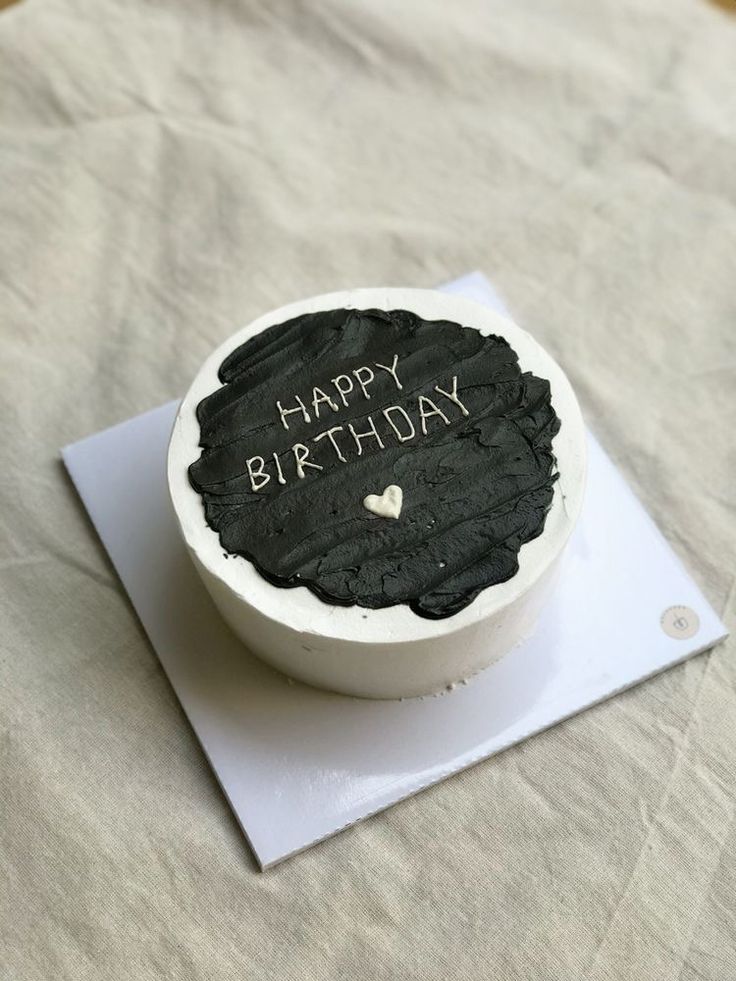 a black and white birthday cake with the words happy birthday written in it on top