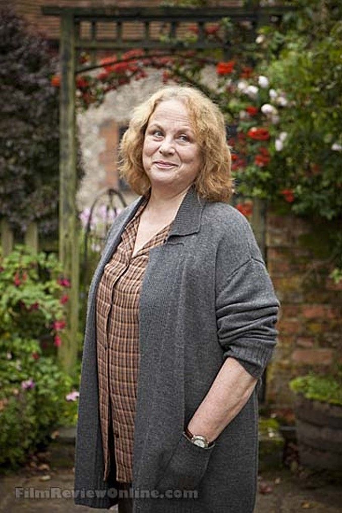 a woman standing in front of some flowers