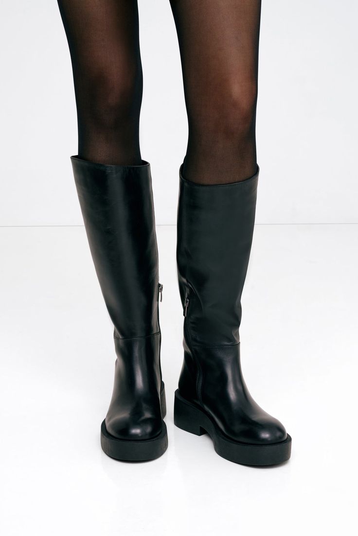 Introducing our master of all trades, the Tilden Boots. This tall, round-toe silhouette is carefully handcrafted for versatility—she’s wide enough to tuck pants into, and slender enough to style with a dress. An asymmetrical top edge and wavy side seams add interest to her practical design, which features a silp-on design, a rear pull tab, and a chunky sole. Please note this design has been updated and, despite the photos, does not include a zipper. | Mily is shown wearing the Tilden Boots. Sold Sweatshirt Fabric, Practical Design, Winter Clothing, Asymmetrical Tops, Outfit Inspo Fall, Pull Tab, Fall And Winter, Boot Shoes Women, Italian Leather