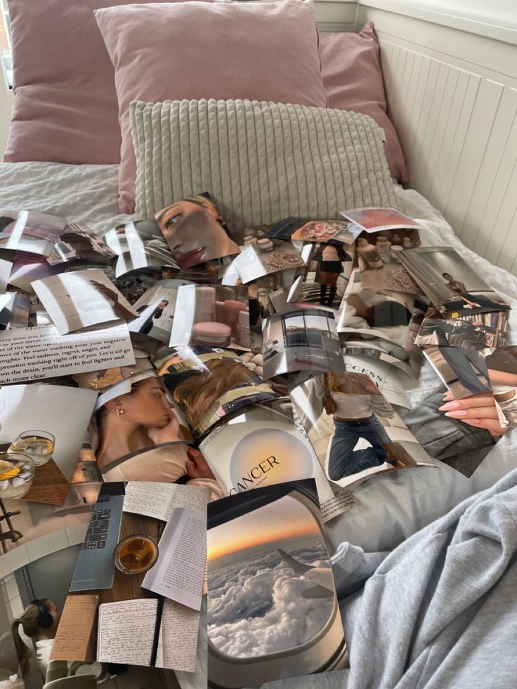 a bed topped with lots of pictures and papers on top of it's side