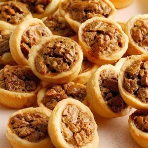 small pastries are arranged on a white plate and placed next to each other in rows