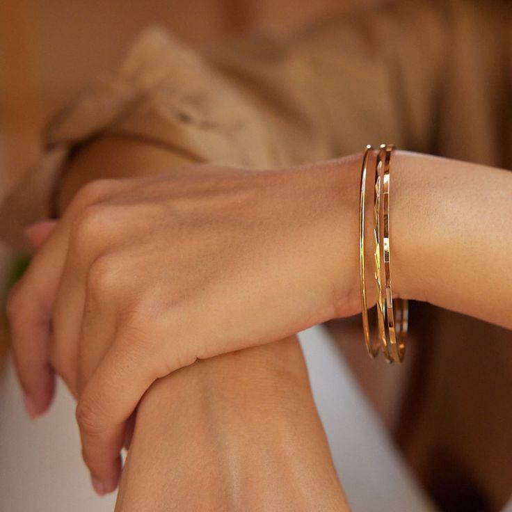 Be irresistibly stylish with this beautiful set of three gold bangle bracelets. Perfect for all occasions, these timeless pieces are sure to make any outfit look chic and modern. Dare to dazzle and embrace your unique style! How will you wear yours? Available in 14k gold plated brass Lucy, Maren and Demi Bangle Bracelets Width: 2mm each Interior diameter measures 2 1/2" SKU: STB1014 Elegant Yellow Gold Bangle For Everyday, Chic Bangle Bracelets For Everyday Luxury, Chic Everyday Luxury Bangle Bracelets, Chic Everyday Luxury Bangle Jewelry, Elegant Stackable Cuff Bracelet For Everyday, Chic Yellow Gold Stackable Bracelets, Flexible Modern 14k Gold Bangle, Chic Gold Stackable Bangle, Elegant Everyday Stackable Bangle