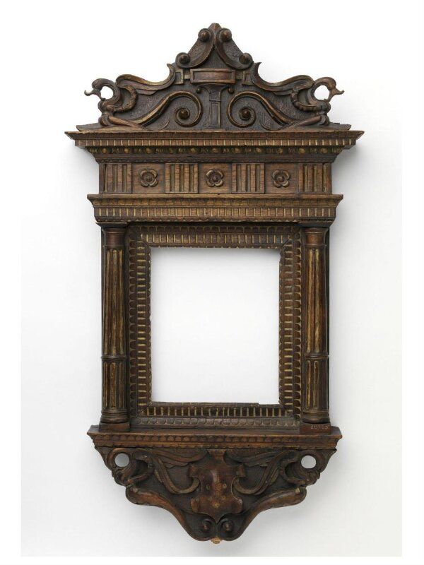 an ornate wooden frame hanging on the wall