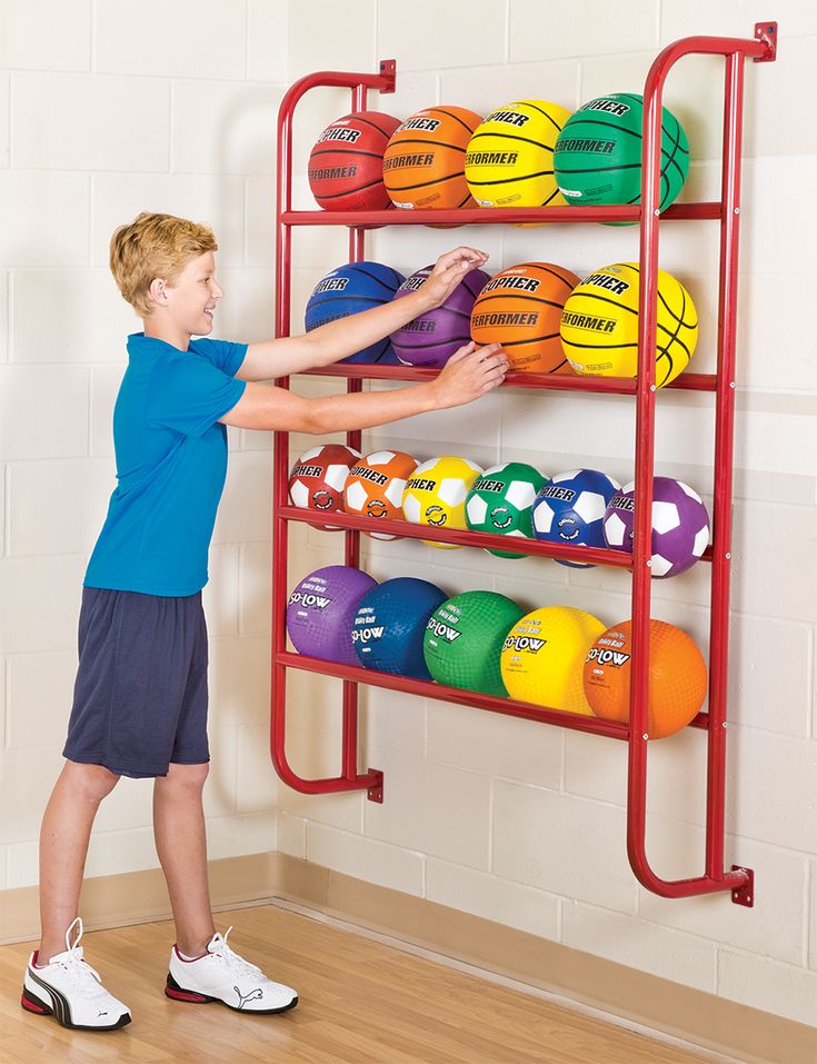 Kid storing basketballs on wall mount rack Kids Garage, Outdoor Toy Storage, Toy Storage Ideas, Sports Equipment Storage, Sports Storage, Shed Organization, Garage Organization Diy, Ball Holder, Garage Organize