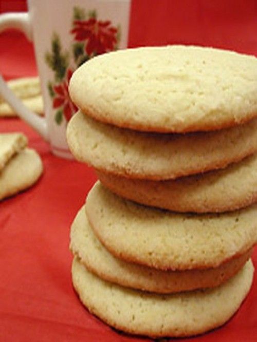 a stack of cookies sitting on top of a table next to a cup and saucer