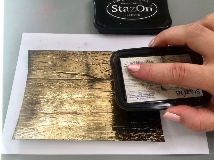 a person holding a cell phone next to a stamp pad