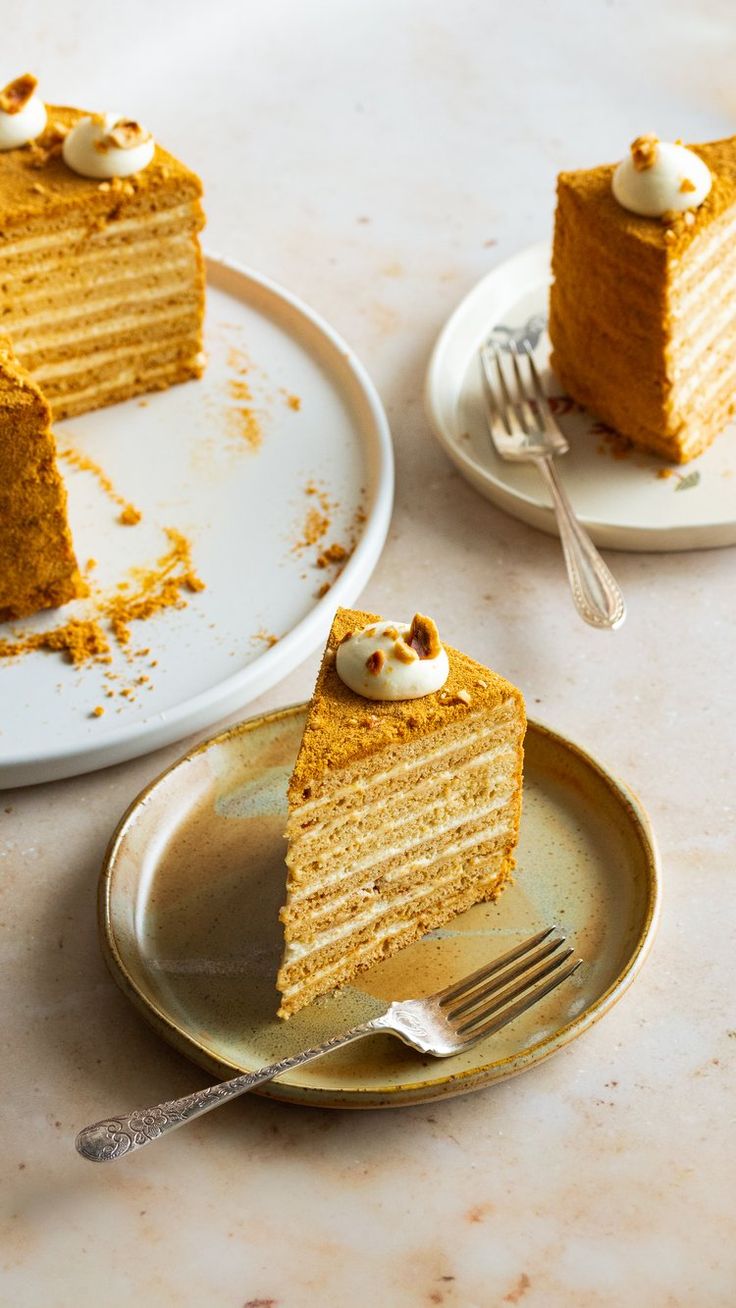 two plates with slices of cake on them, one has a fork in it and the other is half eaten