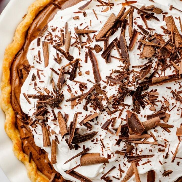 a pie with chocolate and whipped cream on top