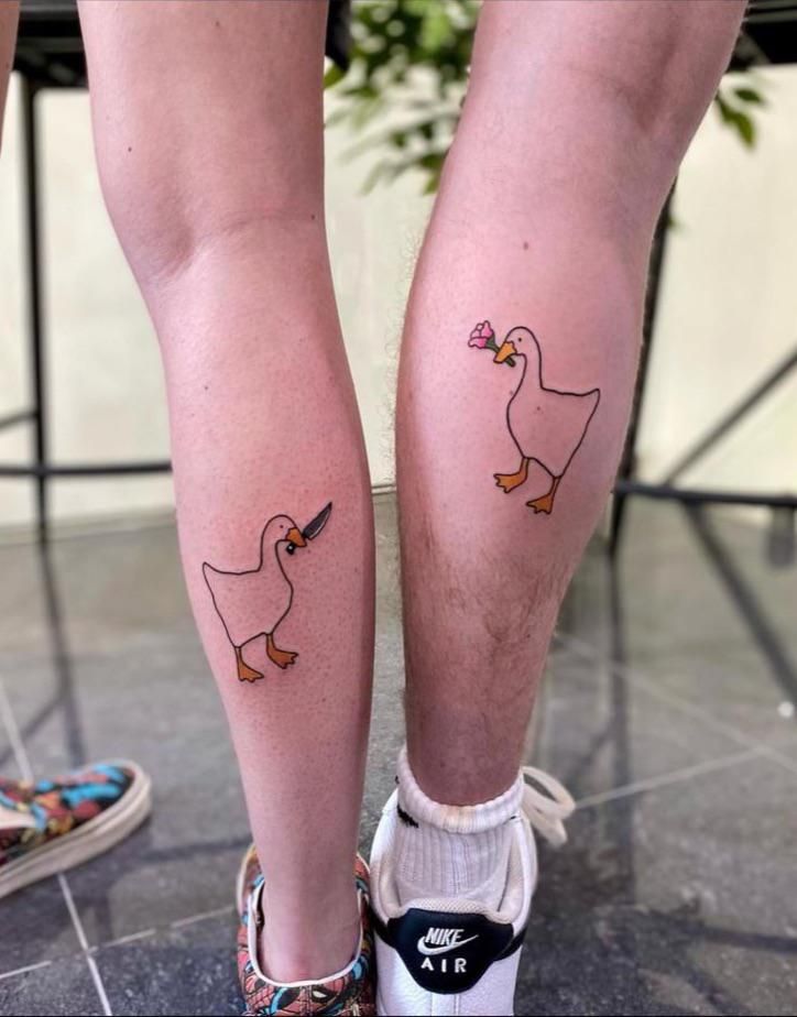 two people with tattoos on their legs, one has a duck and the other has a bow