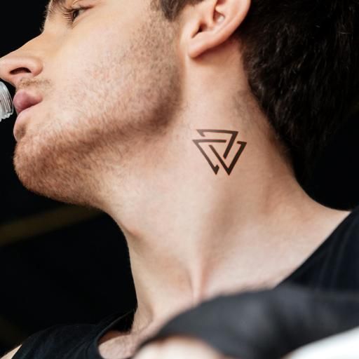 a man with a tattoo on his neck is drinking from a water bottle and looking off to the side