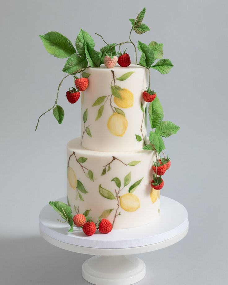 a three tiered cake decorated with fruit and leaves