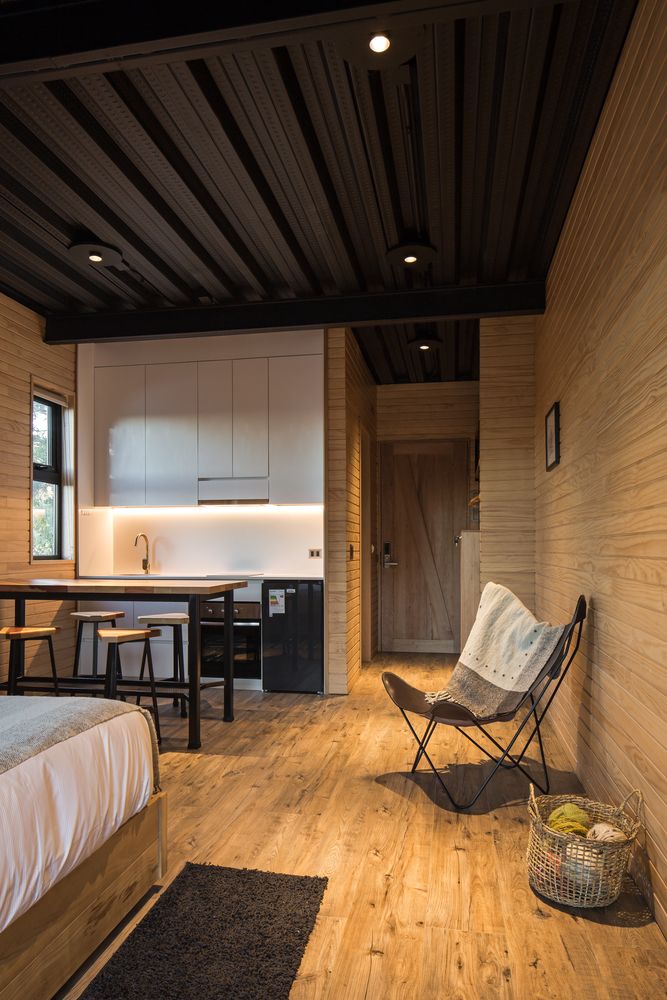 a bedroom with wooden walls and flooring next to a bed