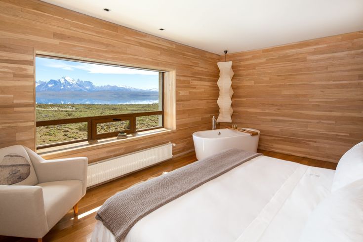 a large bed sitting in a bedroom next to a window with a view of the mountains