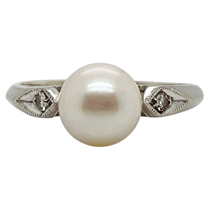 A fine Retro signed pearl cocktail ring. In 14k white gold. Set with 7mm round white pearl and flanked by two small accent diamonds on the shoulder of the setting. Marked to the shank for Rothman & Schneider of New York City. Simply a wonderful Mid-Century ring! Date: Mid-20th Century Overall Condition: It is in overall good, as-pictured, used estate condition with some fine & light surface scratches and other signs of expected light wear consistent with age. Fineness: Marked 14k for gold finene Luxury Vintage White Gold Pearl Ring, Pearl And Diamond Cocktail Rings, Luxury Antique White Gold Pearl Ring, Diamond White Pearl Ring With Center Stone, Round Cut, Antique White Pearl Ring Hallmarked, Pearl Cocktail Ring, Mabe Pearl, Gold Cocktail Ring, White Gold Set