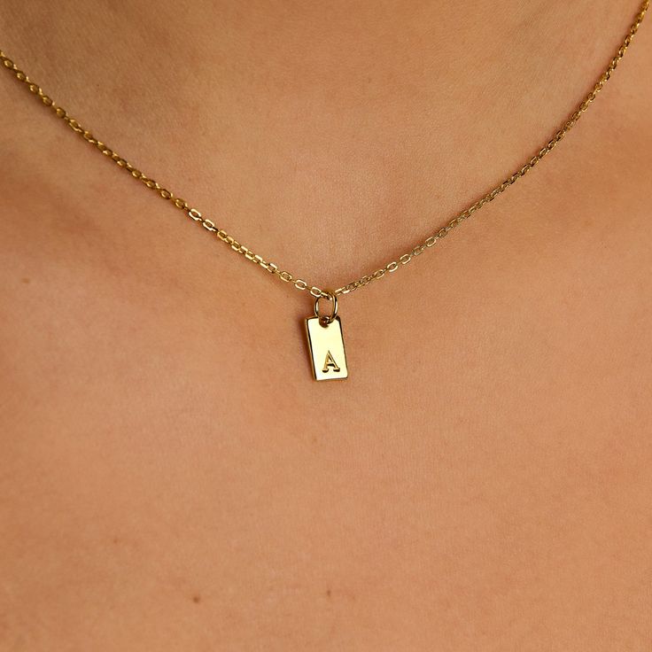 Embrace timeless elegance with this chic initial tag charm, a versatile piece designed to add a personal touch to any ensemble. Featuring a sleek, rectangular silhouette with a subtly embossed initial, this charm crafted from lustrous material is perfect for personalizing your favorite chain, bracelet, or accessory. Ideal for layering or as a standalone statement, this charm is a stylish way to keep a special initial close to your heart. Charm size: 10 mm x 5 mm Made of 14K gold over sterling si Necklace Charms, Gold Gifts, Charm Rings, Birthstone Necklace, Personalized Necklace, Bracelet Stack, Huggies Earrings, Name Necklace, Initial Necklace