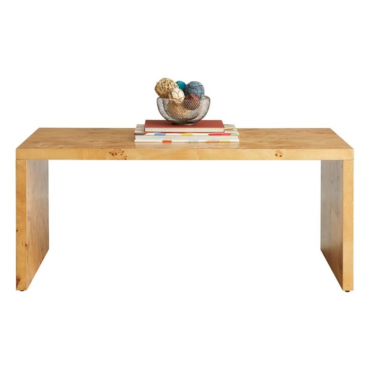 a wooden table with a bowl of balls on top and books in front of it