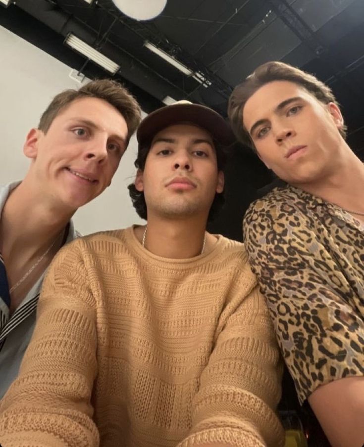 three men sitting next to each other posing for the camera