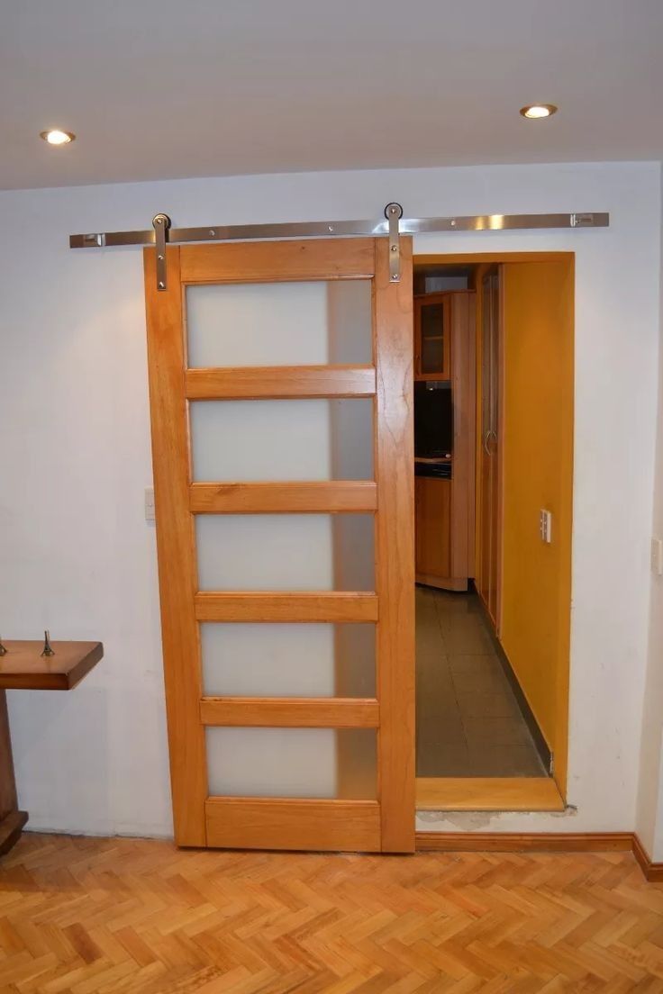 an open wooden door with glass panels in a room