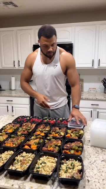 a man standing in front of a table filled with trays of food