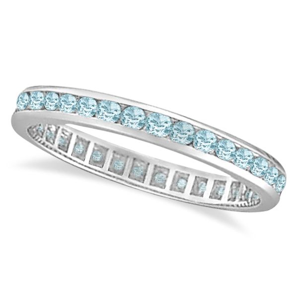 a white gold ring with blue topaz and channeled diamonds on the sides, set in