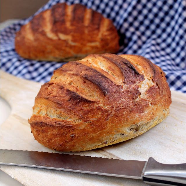 a loaf of bread sitting on top of a cutting board next to a knife