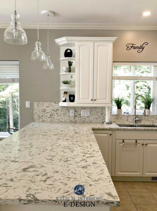 a kitchen with marble counter tops and white cabinets