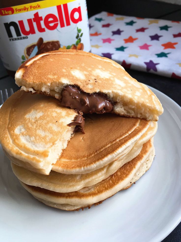 a stack of pancakes on a plate with nutella in the middle