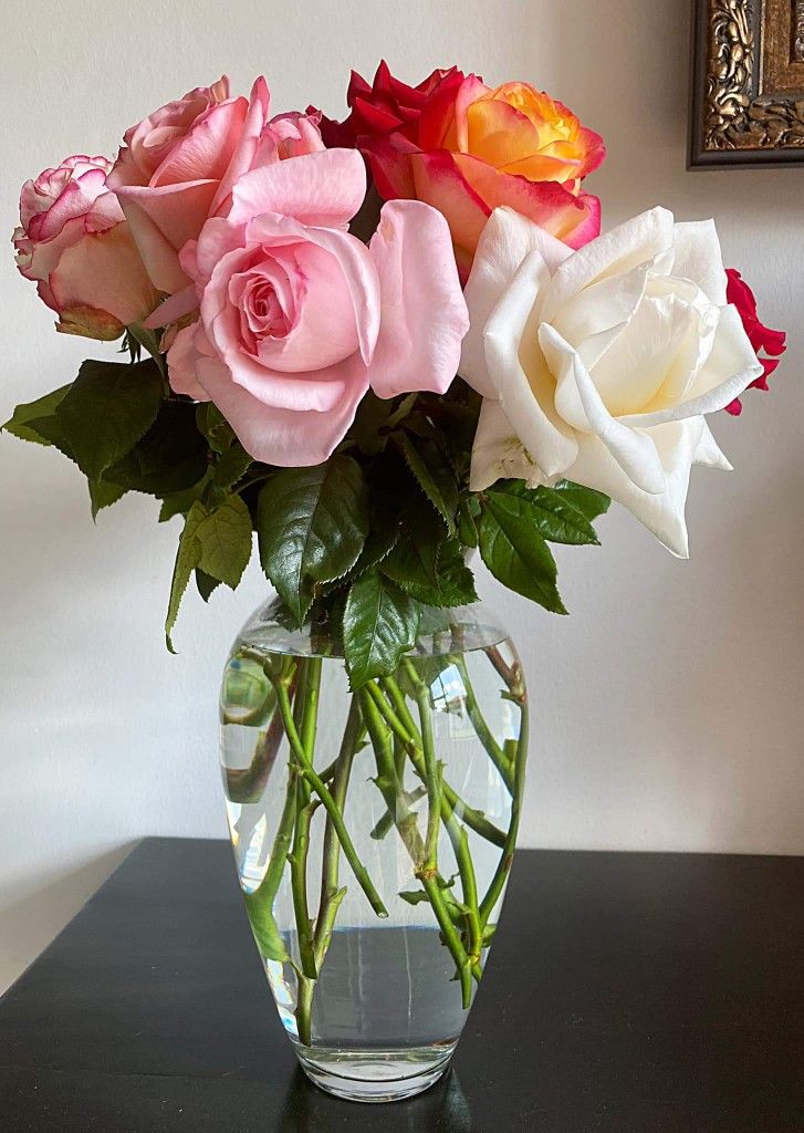 a vase filled with lots of pink and white roses