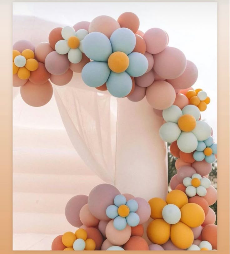 an arch decorated with balloons and flowers for a wedding or birthday party in pastel colors