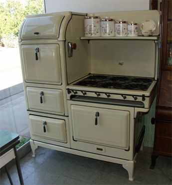 an old fashioned stove with two ovens and cups on it's burners