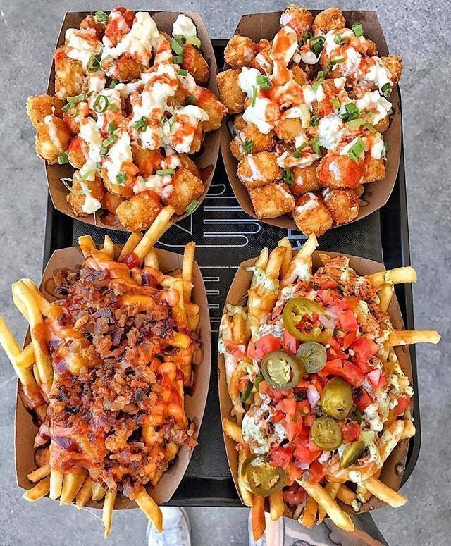 four trays filled with different types of food sitting on top of a metal table