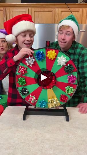 three people wearing christmas hats around a spinning wheel