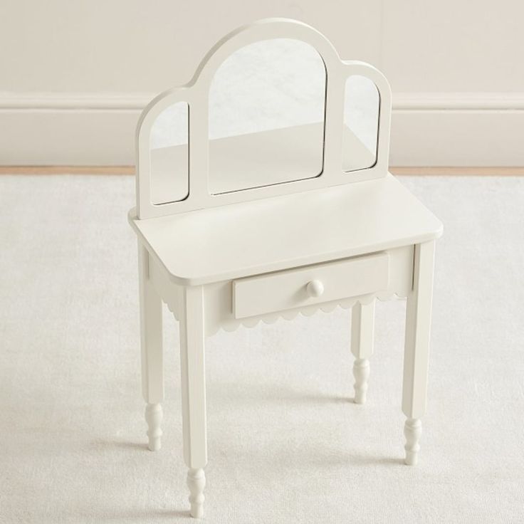 a white vanity table with a mirror on it