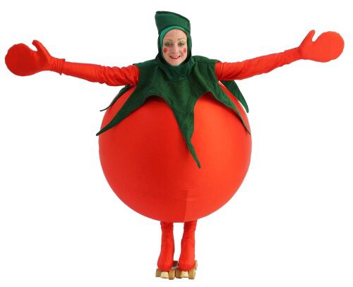 a woman dressed as a tomato standing on top of a large red ball with her arms outstretched