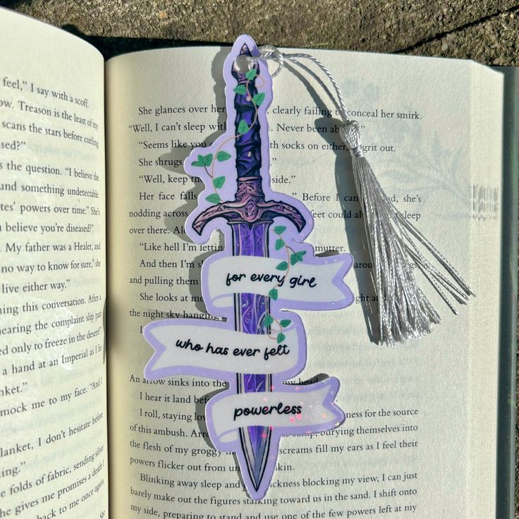 an open book with some stickers attached to it's pages and a tassel