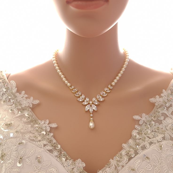 Wedding Necklace in Gold with White Pearl Strand & CZ V-Shaped Pendant On your wedding day, this pearl strand and crystal, gold necklace with a backdrop may just meet all that you are looking for with your bridal and wedding necklace. This beautiful gold necklace is made with pearl strand, a sparkly cubic zirconia pendant in V shape with a beautiful 8 inches most elegant pearl backdrop for your low back or backless wedding dress. This gold necklace for the wedding has a detachable backdrop so th Gold Necklace For Wedding, Wedding Necklaces For Bride, Durga Jewellery, Pearl Backdrop, Necklace For Wedding, Necklace For Neckline, Gold Pearl Jewelry, Gold Bridal Necklace, Backdrops Necklace