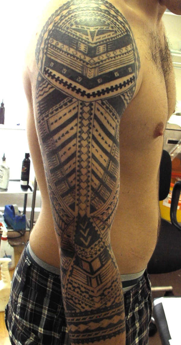 a man's arm with an intricate tattoo design on the upper half of his body