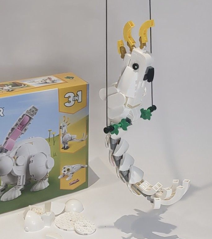 a toy horse is in front of a box with parts attached to it and on the ground