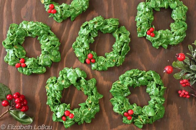 christmas wreaths made out of green paper on a table