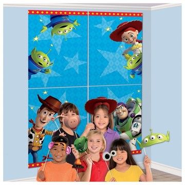 a group of children standing next to each other in front of a wall with cartoon characters on it