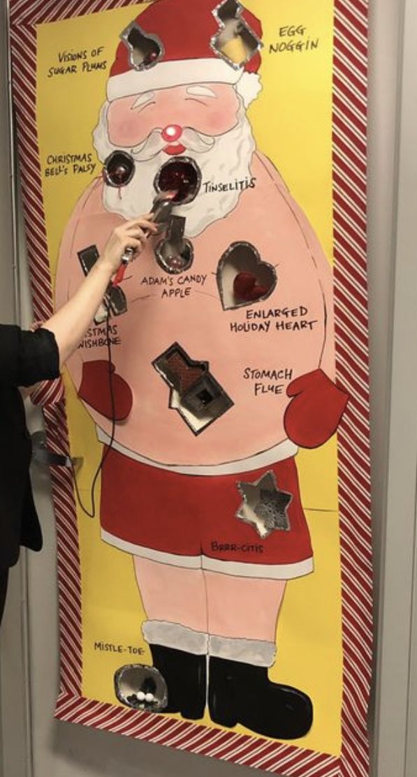 a woman standing in front of a poster with santa clause on it's face