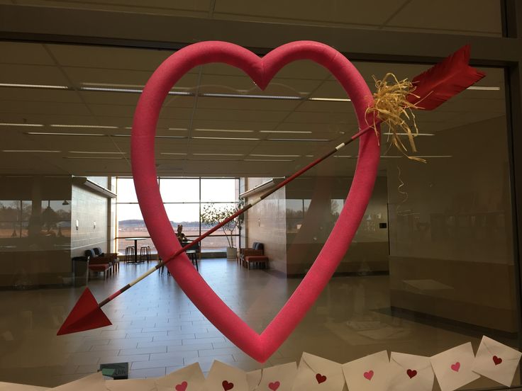 a heart shaped sculpture with an arrow in the middle and hearts cut out of paper