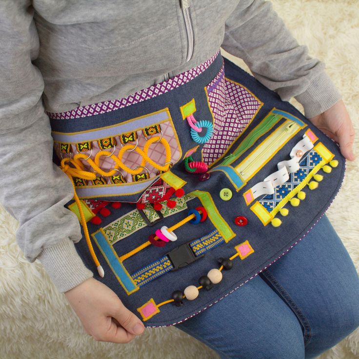 a woman is holding a purse made out of various things in her hands, including scissors and beads