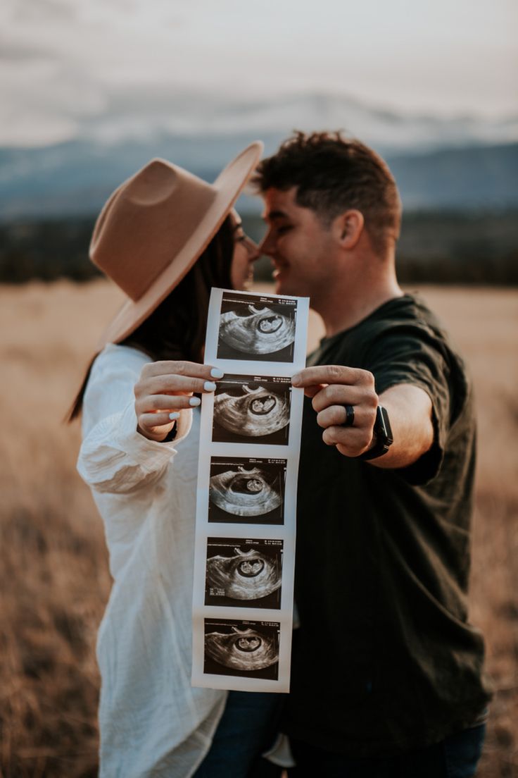 a man and woman holding up an x - ray photo in the middle of a field