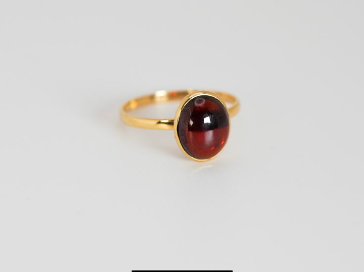 Materials: 14K Gold Ring Size: 6.75 Hallmarks: 14K LNT IN Total Weight (grams): 1.80 Primary Stone(s) Type: Garnet Primary Stone(s) Shape: Oval Cabochon Primary Stone(s) Dimensions: 10.00 mm x 8.00 mm * This item has been evaluated and verified by a GIA Graduate Gemologist.  * All diamond and gemstone grading is done under GIA standards as the mounting permits, where gemstones are present; where mountings impede accurate measurements, (estimated) dimensions are provided. All weights and measurem Classic Gold Ruby Cabochon Ring, Classic Gold Ruby Ring With Cabochon, Classic Oval Rings With High Luster, Classic Oval Ring With High Luster, Classic Oval High Luster Ring, High Luster Oval Ring In 14k Gold, High Luster 14k Gold Oval Rings, Classic Amber Rings For Formal Occasions, Formal Amber 14k Gold Ring