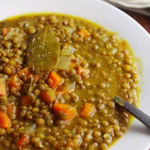 a white plate topped with lentils and carrots