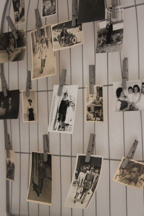 many pictures are hanging on the wall with clothes pins