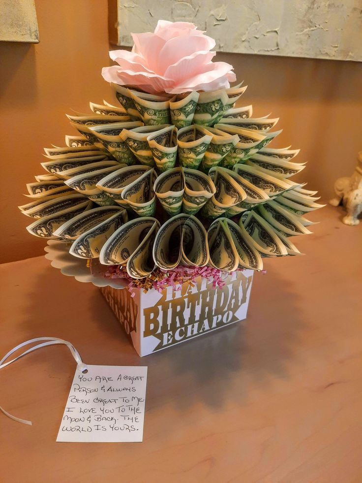 a birthday cake made out of books on a table with a note attached to it