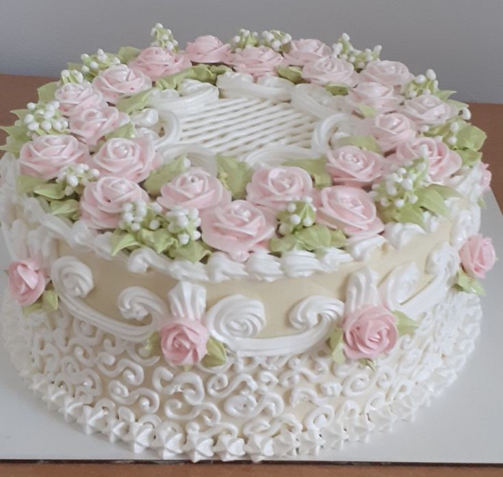 a cake with white frosting and pink flowers on it