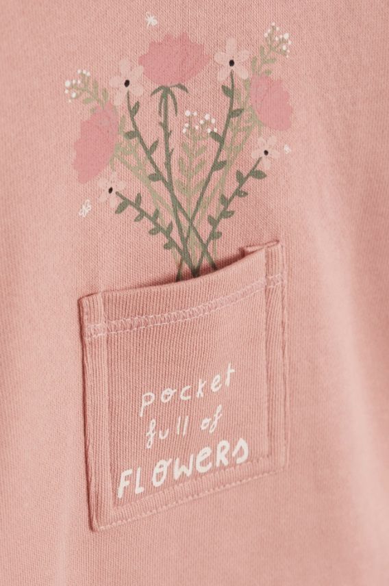 a pink shirt with flowers in the pocket